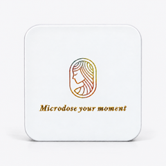 White square metal tin that reads "microdose your moment" on the front with a goddess logo in rainbow