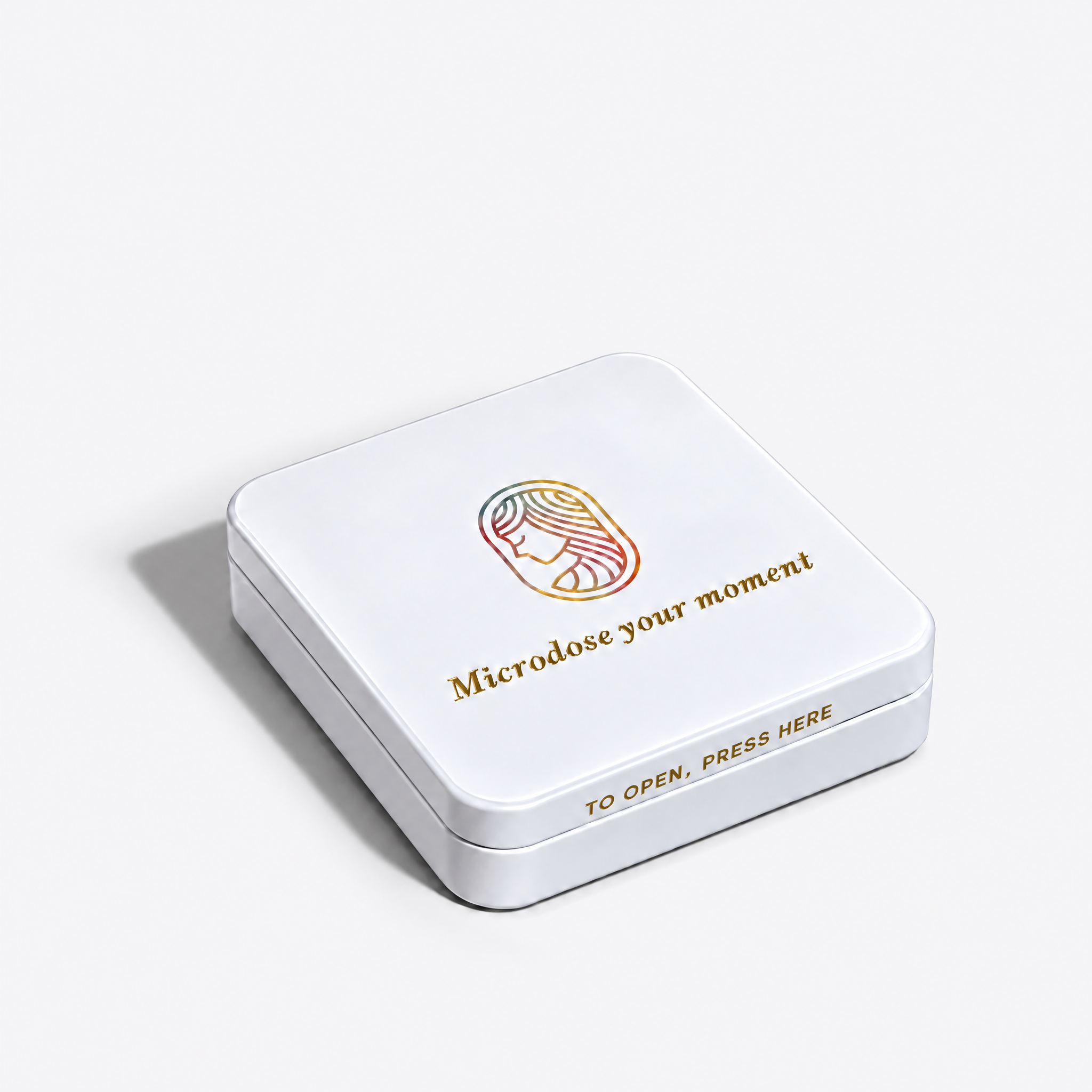 White square metal tin that reads "microdose your moment" on the front with a goddess logo in rainbow