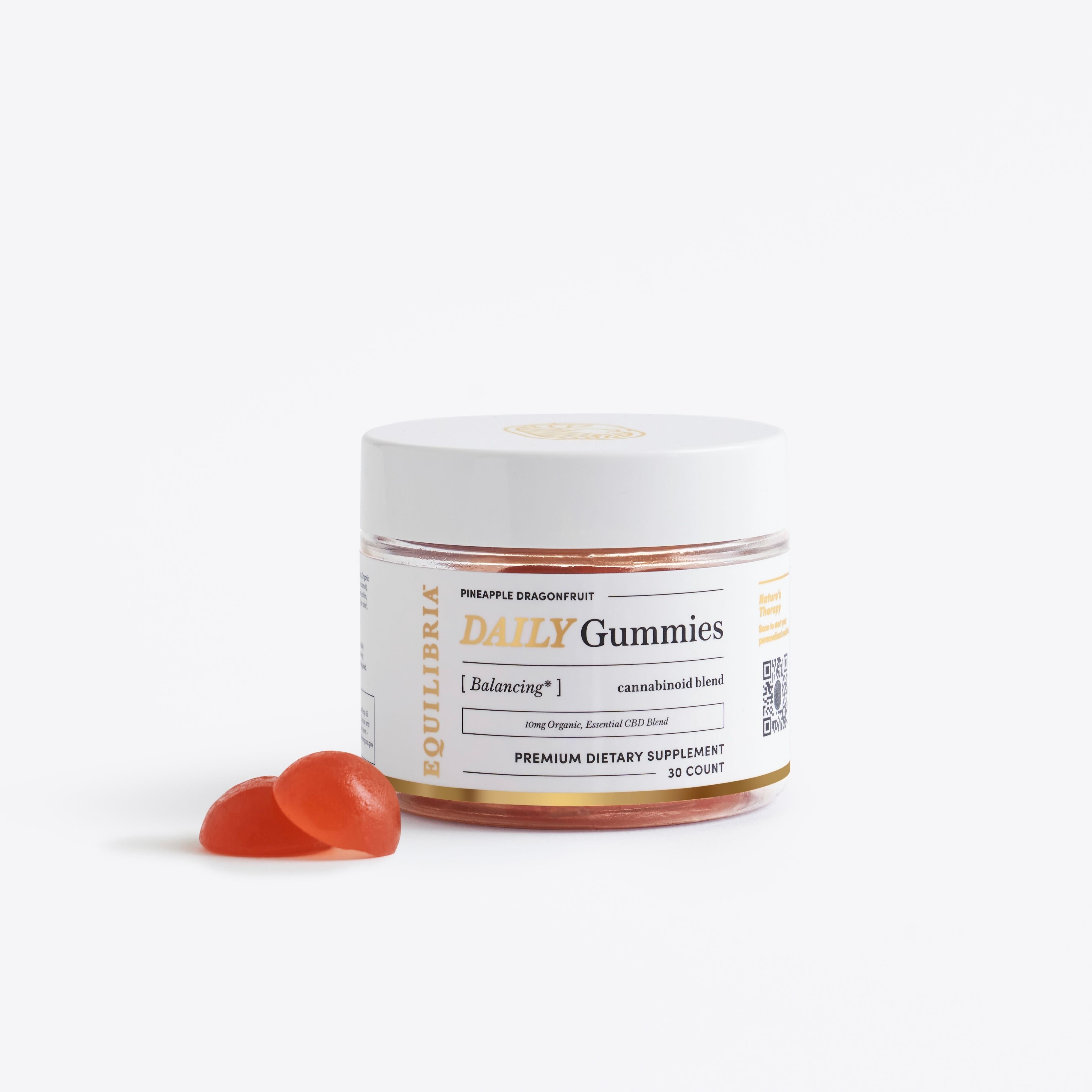 Jar of 'CBD Daily Gummies' supplement with two gummies on a white background