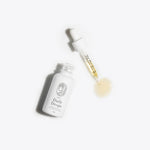 CBD tincture bottle and dropper on white background