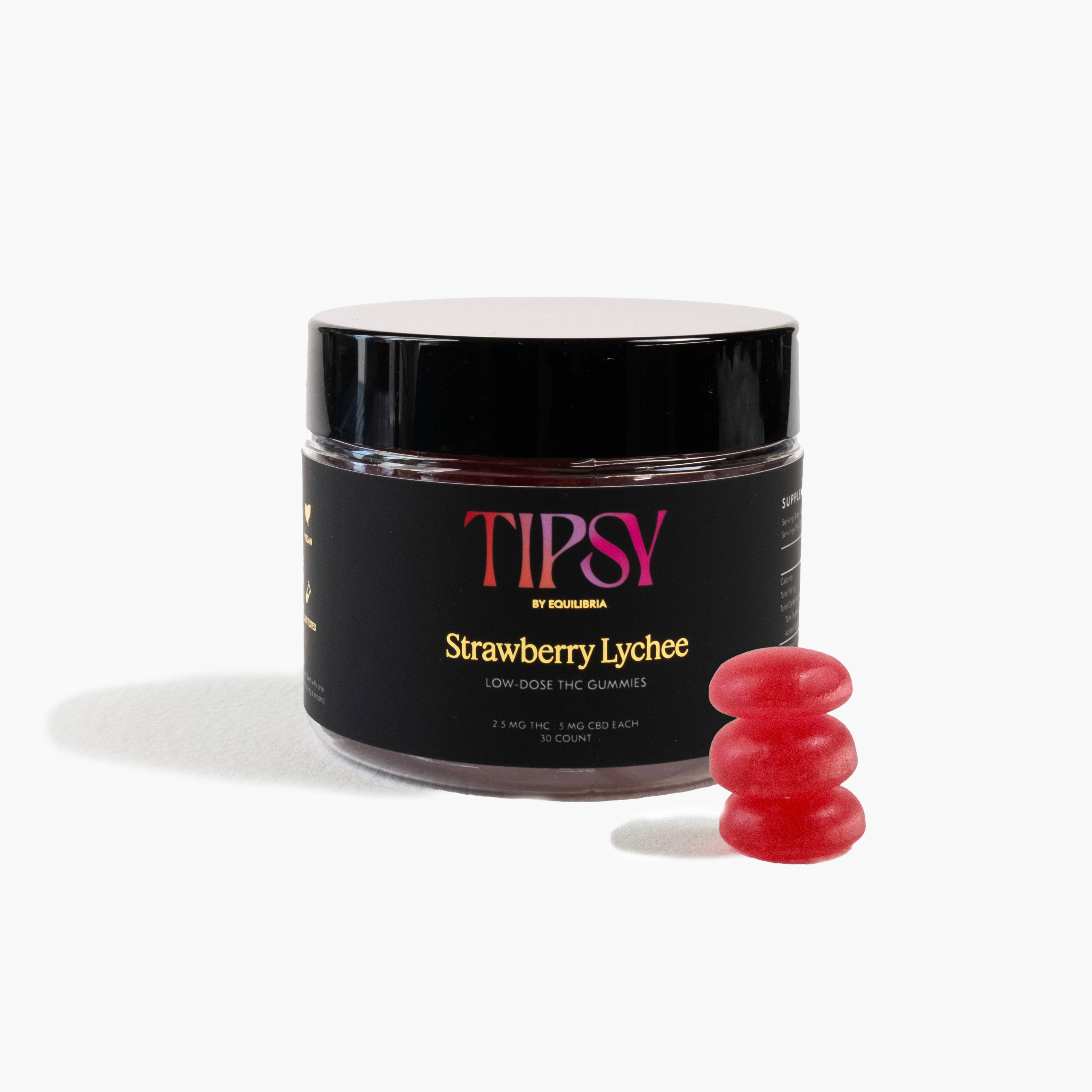 A jar of Tipsy THC Gummies with 3 gummies stacked on top of each other next to it, on a white background